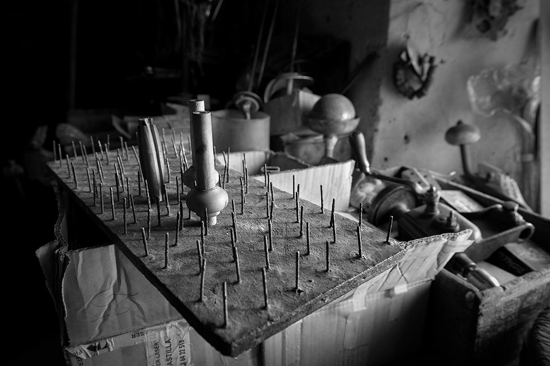 Utensils and a board with nails in a dark interior.